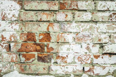 Harap olmuş eski bir kırmızı tuğla duvar soyut bir arka plan olarak beyaza boyanmış..