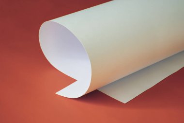 Kırmızı zemin üzerinde ince bir karton yaprak.