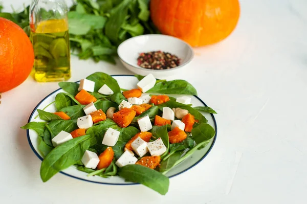 Açık beton arka planda balkabağı, ıspanak ve beyaz peynir ile parlak bir sonbahar salatası. Diyet sağlıklı yemek. Yukarıdan bak. Metin için bir yer. — Stok fotoğraf