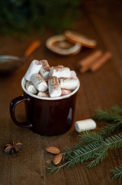 Noel kakaosu, marşmelov ve noel ağacı şeklinde lolipop, kahverengi bir fincanda ahşap bir arka planda. Dikey fotoğraf. Seçici odak.