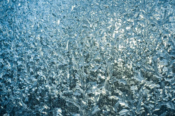 Za úsvitu mrazivé vzory na okně. Frosty textura okna. Abstraktní pozadí. — Stock fotografie