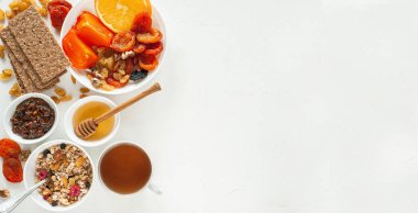 Kış meyveleri, kurutulmuş meyveler, granola ve çayla vejetaryen kahvaltısı. Bağışıklık sistemini güçlendiriyorum. Yukarıdan bak. Metin için bir yer.