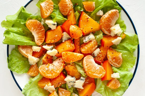 Salade aigre-douce avec kaki, mandarines et fromage bleu. Des vitamines d'hiver. Gros plan. Vue d'en haut. — Photo