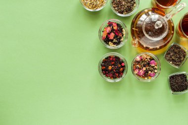 Yeşil arka planda farklı türde yeşil, siyah ve bitkisel çay. Lezzetli organik içecekler. Yukarıdan bak. Metin için bir yer.