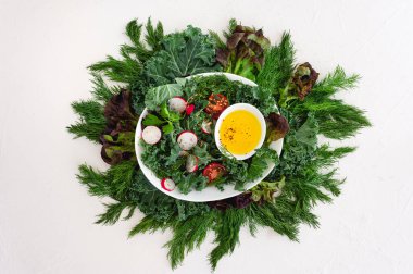 Lahana salatası, otlar, domatesler ve turplar beyaz arka planda malzemelerle beyaz oval bir tabakta. Vejetaryen yemeği. Sağlıklı beslenme. Diyet öğle yemeği.