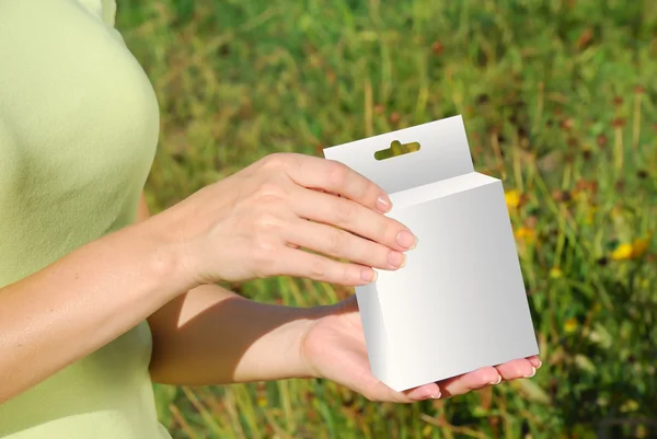 Manos sosteniendo una caja blanca — Foto de Stock