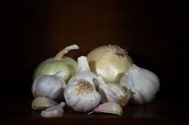 Siyah arka planda organik bahçeden sarımsak ve soğanlar..