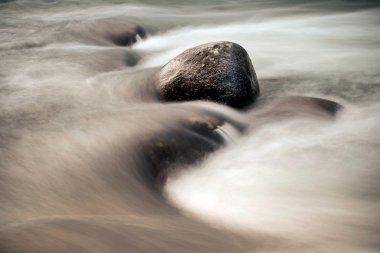 Stones among rapid water flow clipart