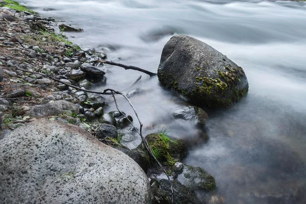 Pedras entre o fluxo de água rápido — Fotografia de Stock