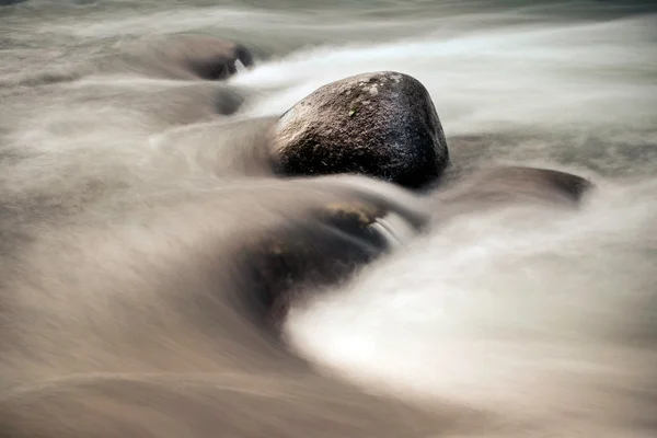 Pedras entre o fluxo de água rápido — Fotografia de Stock