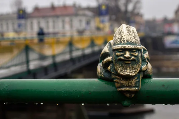 Маленькая статуя гнома на мосту под дождем — стоковое фото