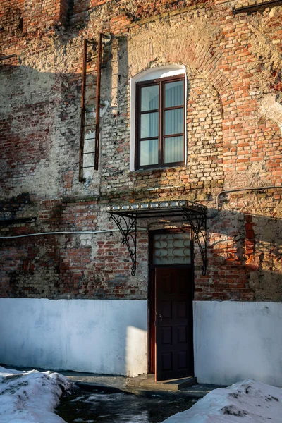 Antigua pared de ladrillo con una puerta, una ventana y escaleras — Foto de Stock