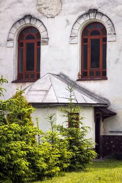 Windows of white Catholic Church in Slovakia close to firs — Stock Photo, Image