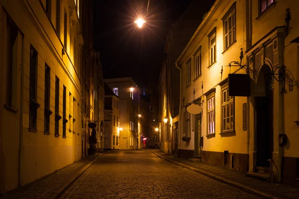 Gece parlak ışıkların altında Riga'da sokak Güz