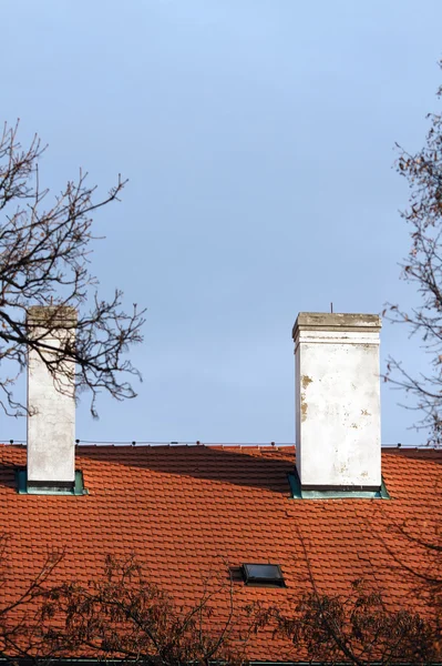 Red tile roof with chimney on blue sky background — Stock Photo, Image