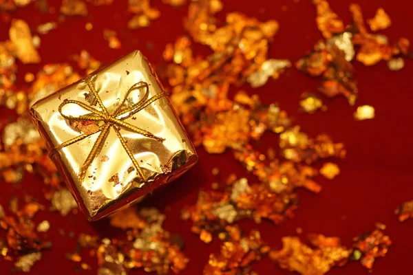Golden decorative box with holiday gift on red background Stock Photo