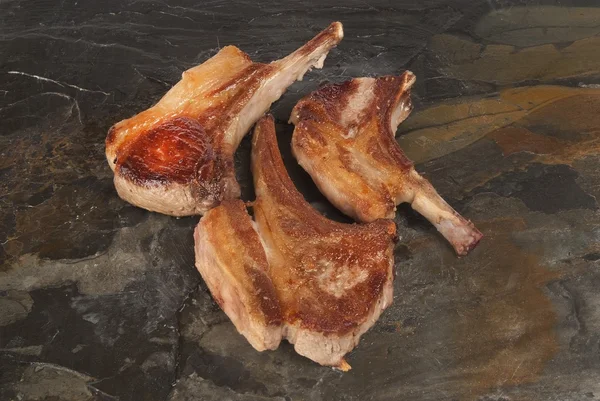 Chuletas de cerdo contra pizarra gris — Foto de Stock