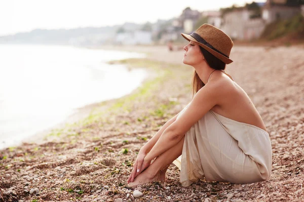 Rustige vrouw zitten alleen aan een zandstrand — Stockfoto