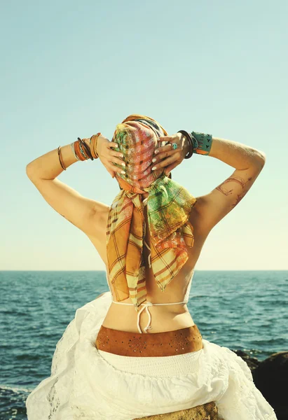 Young fashion woman back, girl sitting on a stone against seascape — Stock Photo, Image