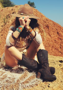 Gezgin bir kürk kaya, safari seyahat kavramı üzerinde oturan kadın moda