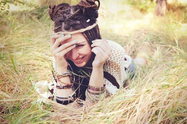 Young hippie smiling woman with headband on her head have a fun lying outdoor in sunny park — Stock Photo, Image