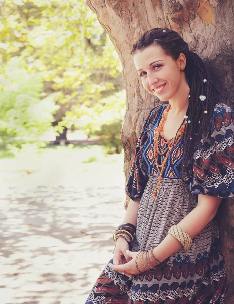 Schattige lachende hippie indie stijl vrouw met dreadlocks, gekleed in boho stijl decoratieve jurk poseren buiten — Stockfoto