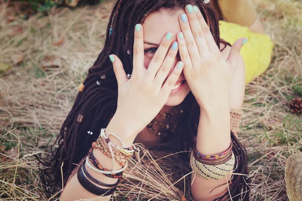 Joyful indie style woman with dreadlocks hairstyle, have a fun closing her face with a hands — Stock Photo, Image