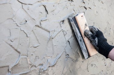 Dekoratif alçı kaplama, usta Venedik sıvasının dokusunu malayla yapıyor, yüzü yok.