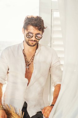 Güneş gözlüğü takmış seksi erkek modeli portresi.