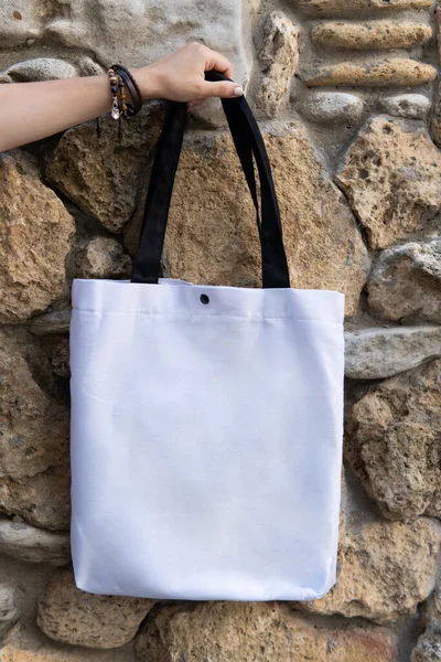 Mujer Mano Sosteniendo Bolsa Mano Blanca Contra Pared Piedra Sin — Foto de Stock