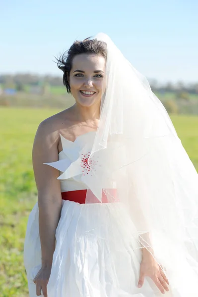 Счастливая Невеста Наружный Портрет Белом Платье Текстильным Цветом Красной Лентой — стоковое фото