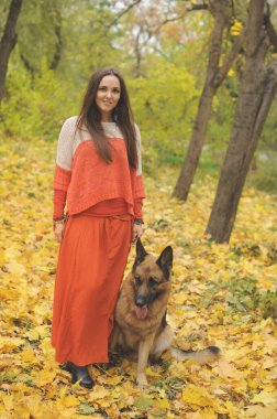 Alman çoban köpeğini Sonbahar Park açık ile yürüyen mutlu genç kadın