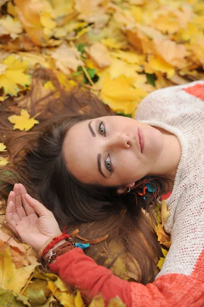 年轻美丽的女子画像 躺在秋天的树叶里 秋天的室外 — 图库照片