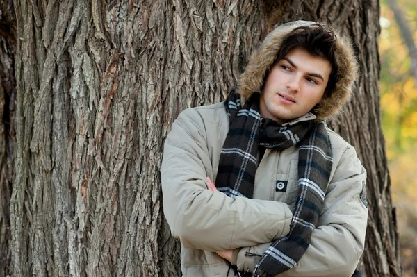 Hombre con chaqueta y capucha en el parque otoñal . — Foto de Stock