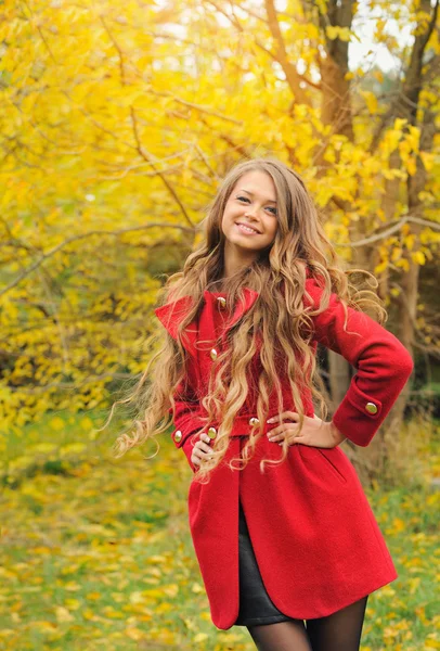 Mode vrouw gekleed in rode jas in herfst park. — Stockfoto