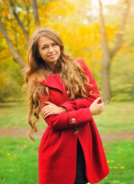 Mulher de moda vestida de casaco vermelho no parque de outono . — Fotografia de Stock