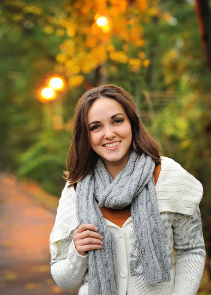 Woman wearing knitted scarf in evening park. — Stock Photo, Image