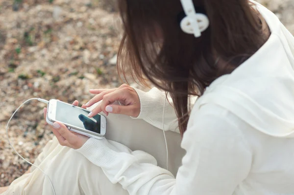 Giovane donna che ascolta musica con telefono contro sabbia marina . — Foto Stock