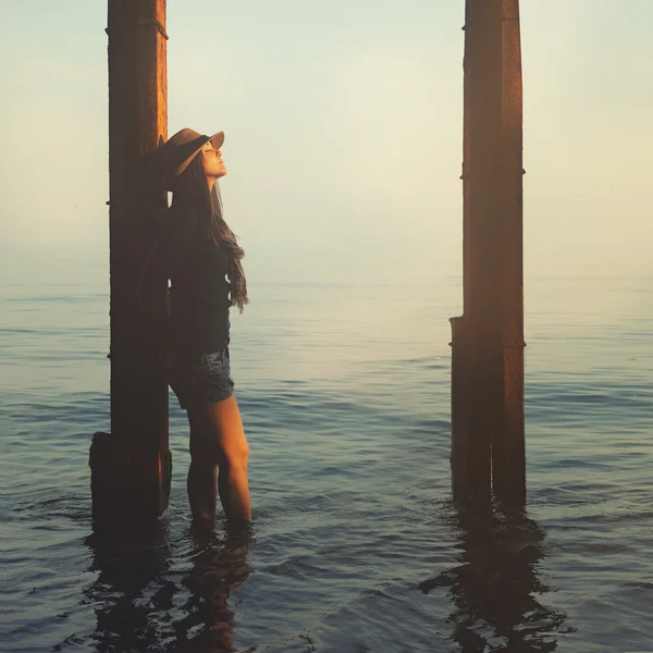 Smiling hipster girl walking on a sea beach. — Stock Photo, Image