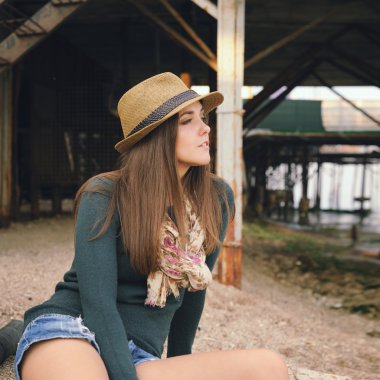 Bir deniz plajda eski İskelenin altındaki dinlenme güzel hippi kız.