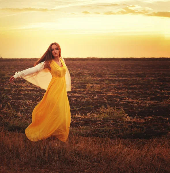 Lachende vrouw buiten portret liggend op een zee zand en luisteren muziek, top weergave. — Stockfoto