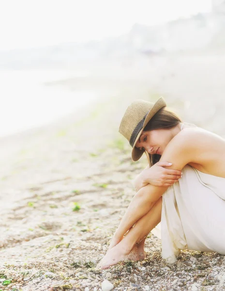 Mujer joven y tranquila relajarse sentado en una playa de arena de mar, romántica mañana brumosa . — Foto de Stock