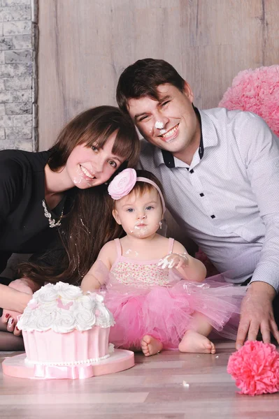 Família feliz - mãe, pai e filha celebrando o primeiro aniversário com bolo . — Fotografia de Stock