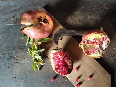 Olgunlaşmış büyük meyve, tahta bir masada nar açtı.