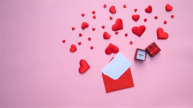 Bir sürü kırmızı kalp, bir zarf ve pembe arka planda bir hediye. Kopya alanı. Banne