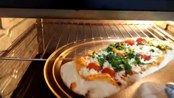 オーブンでおいしい自家製ピザベーキング モッツァレラチーズ チルドトマト アルグラ オーブンでイタリア料理 食品の背景 — ストック動画