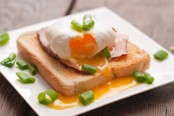Läcker frukost. ägg benedict med skinka på toast. — Stockfoto