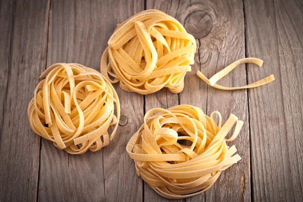 Homemade tagliatelle. Uncooked pasta on the wooden table — Stock Photo, Image