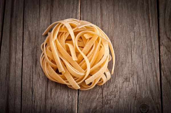 Homemade tagliatelle. Uncooked pasta on the wooden table — Stock Photo, Image