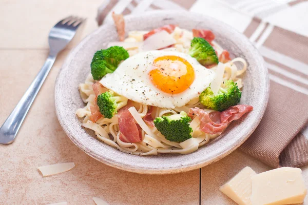 Pasta de tagliatelle con brócoli, jamón y huevo frito . — Foto de Stock